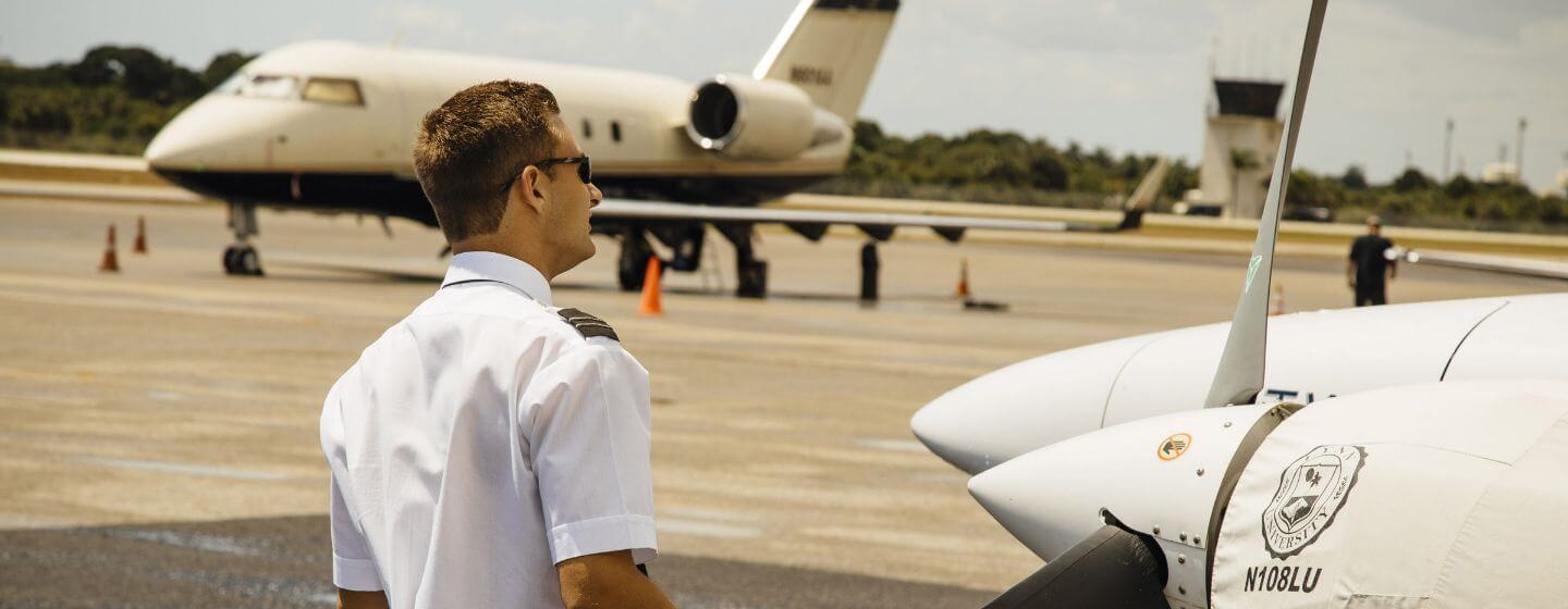 Lynn aviation student in uniform standing in an airfield