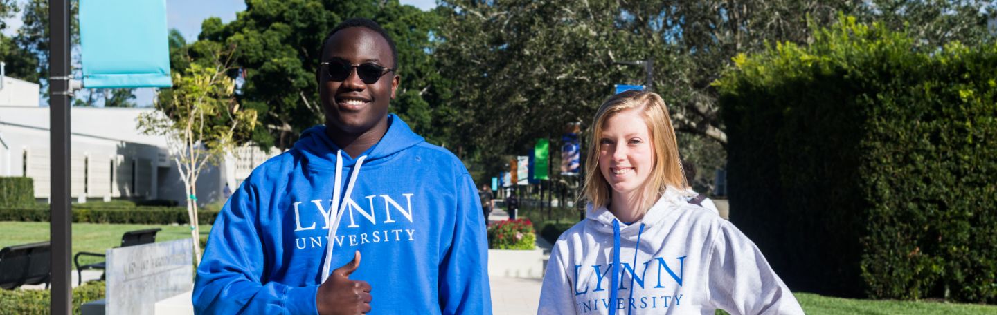 Two smiling Lynn students in Lynn sweatshirts on campus