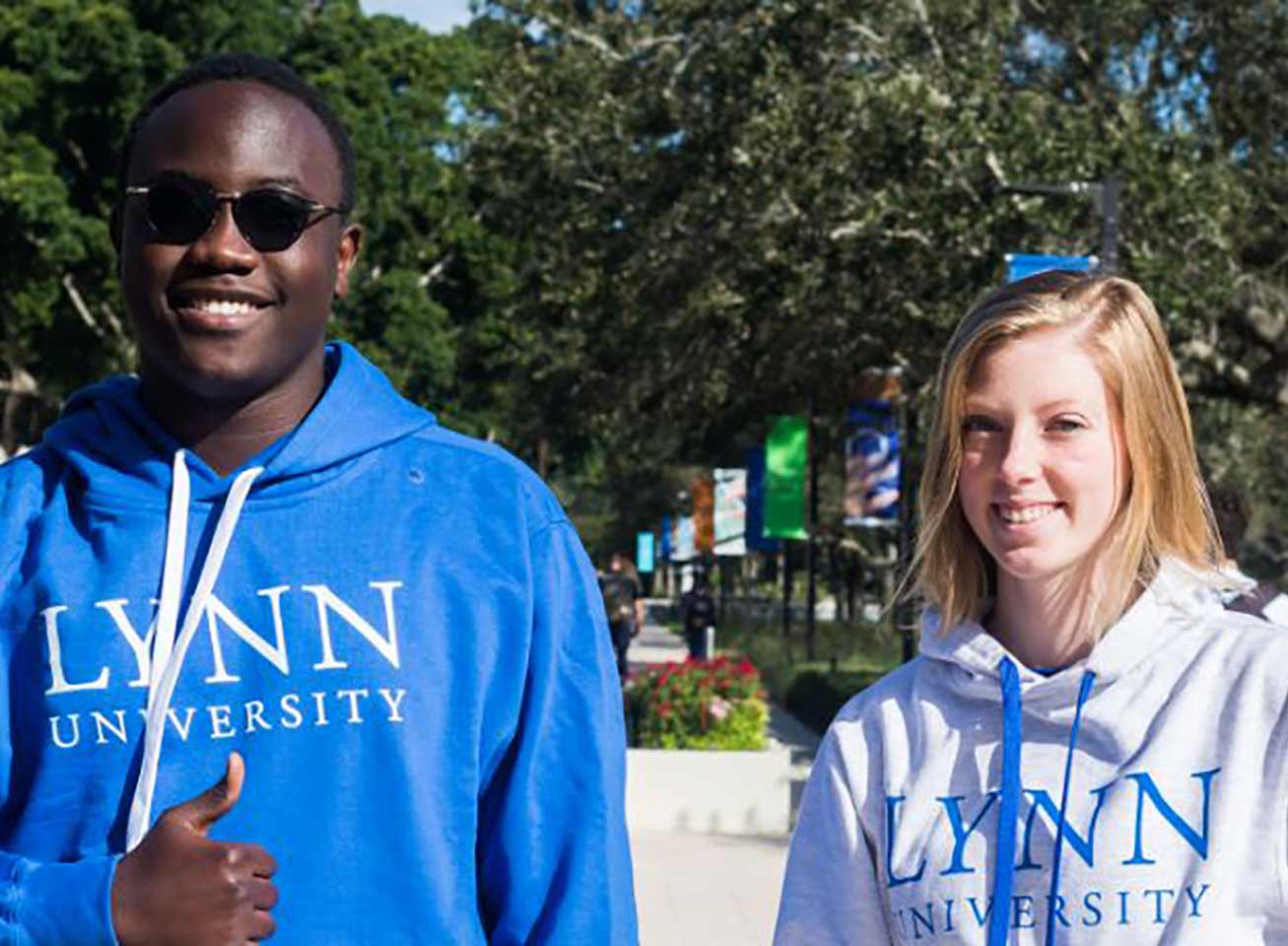Two smiling Lynn students in Lynn sweatshirts on campus