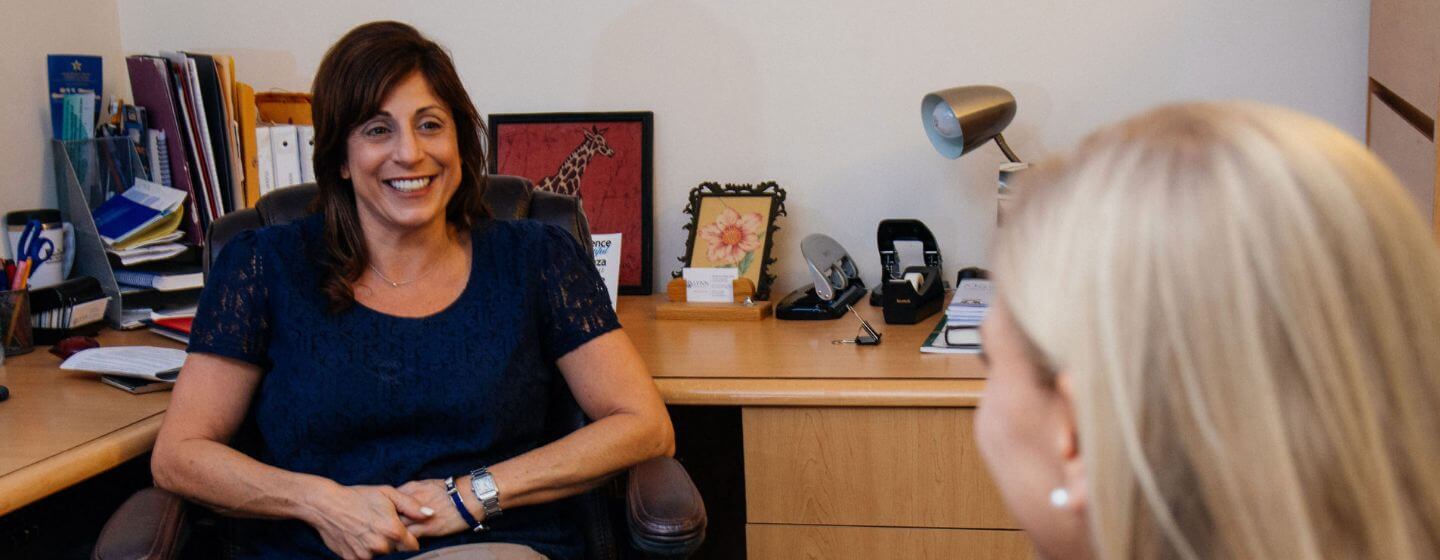 Lynn psychology instructor speaking with a student in an office