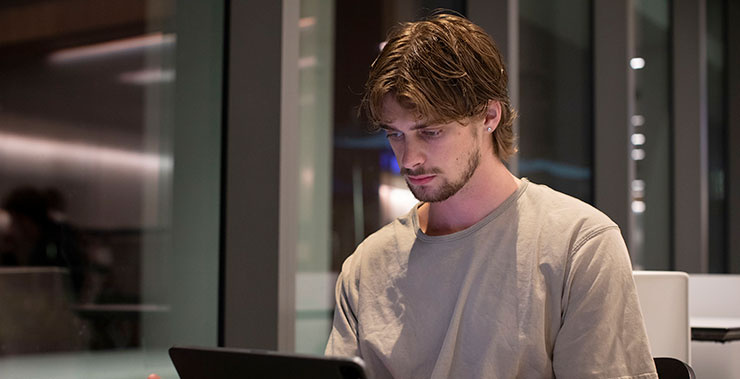 A business student studying on his laptop.