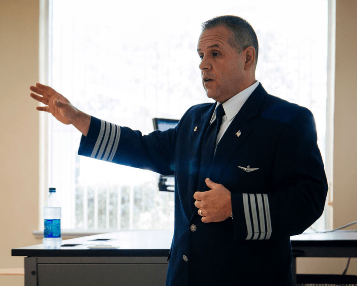 Lynn aviation instructor in uniform, speaking in a classroom
