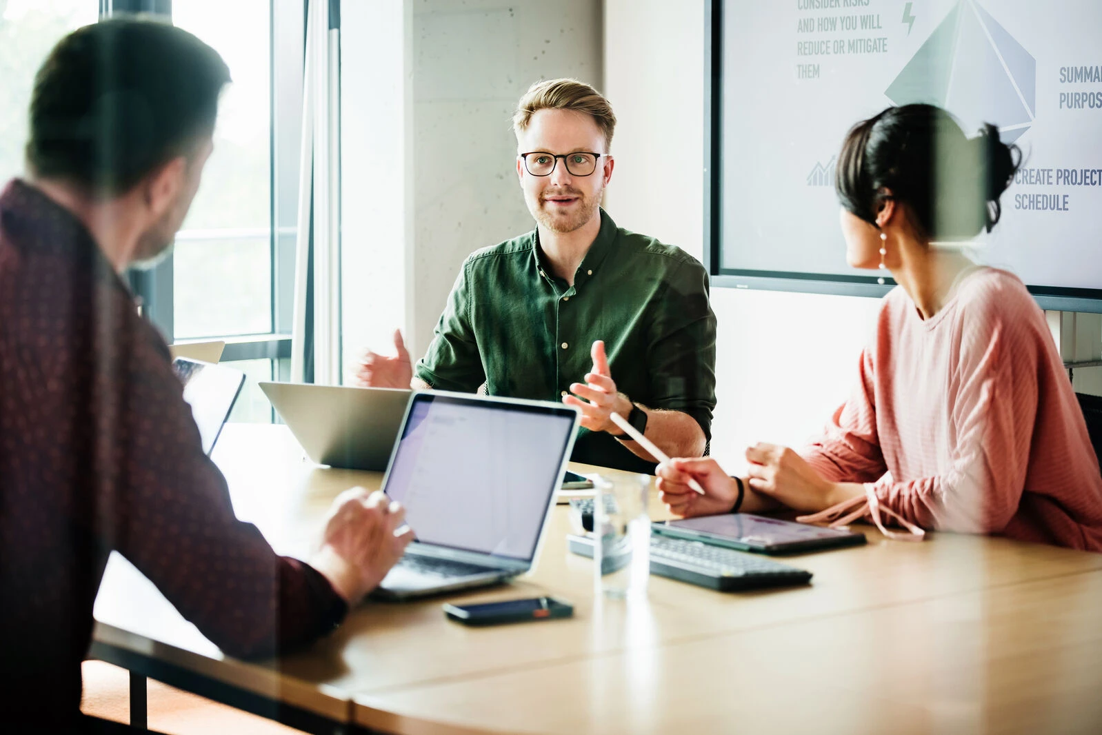 A group of professionals discussing options for trade promotion management software.
