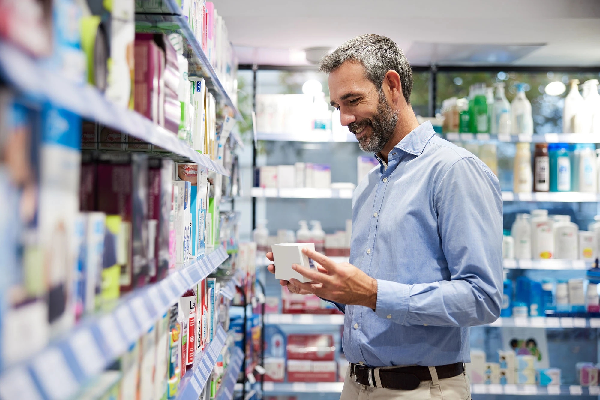Man shopping in grocery store reviews products optimized with Blacksmith software acquired by TELUS Agriculture & Consumer Goods. 

