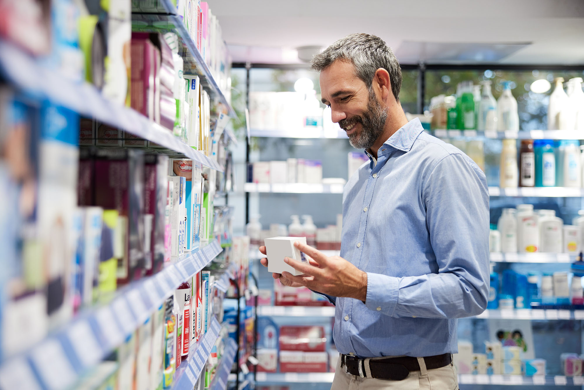 Man shopping in grocery store reviews products optimized with Blacksmith software acquired by TELUS Agriculture & Consumer Goods.