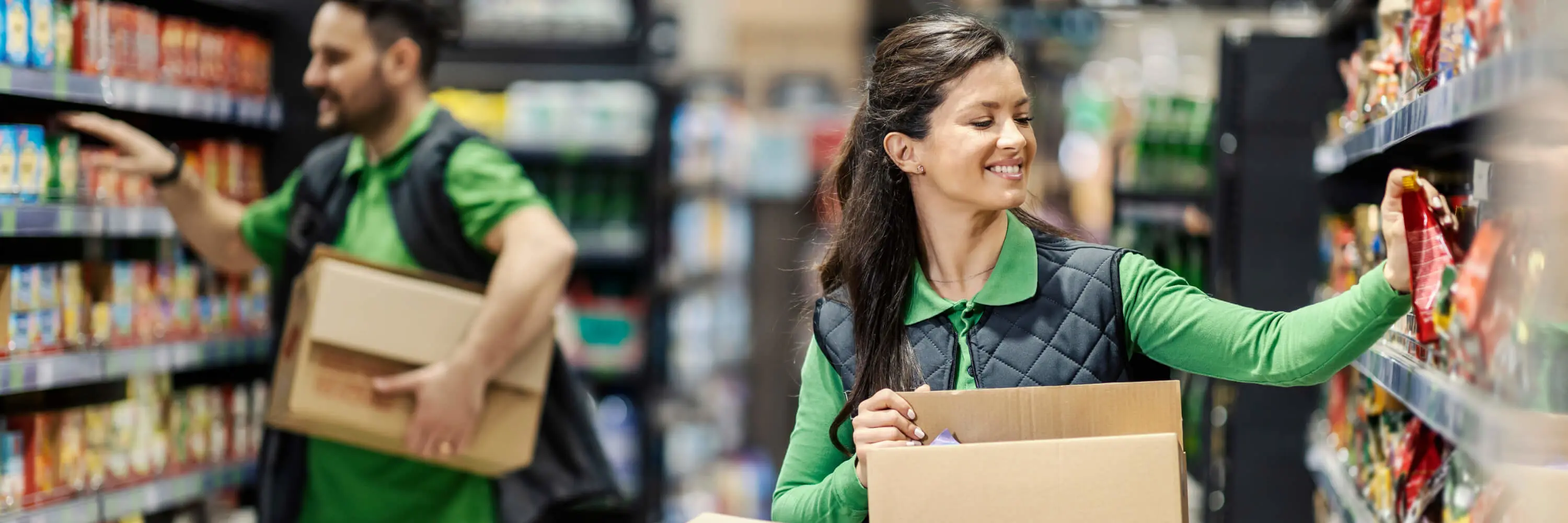 A woman is holding a box in a grocery store.