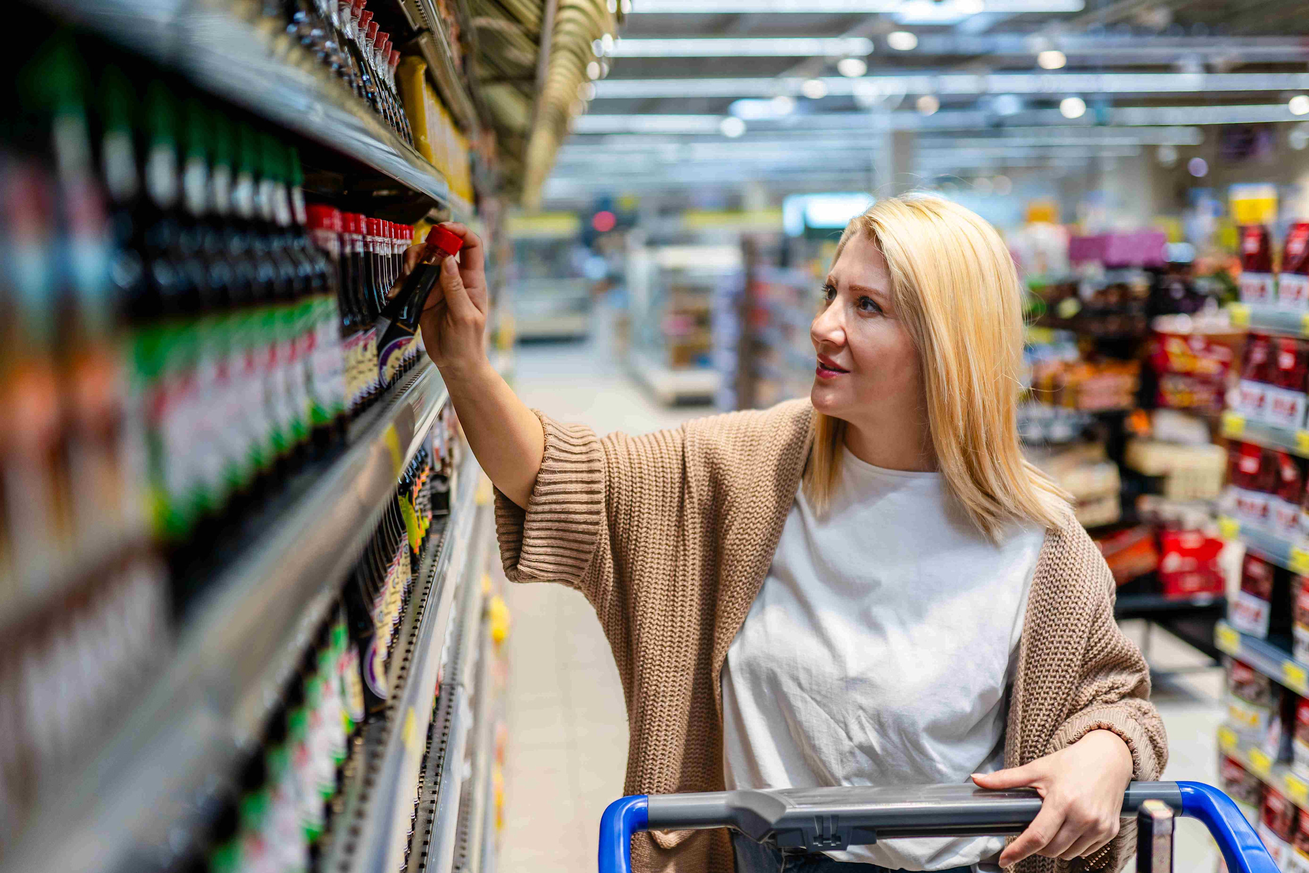 Woman selecting product in retail after consumer decision tree research.