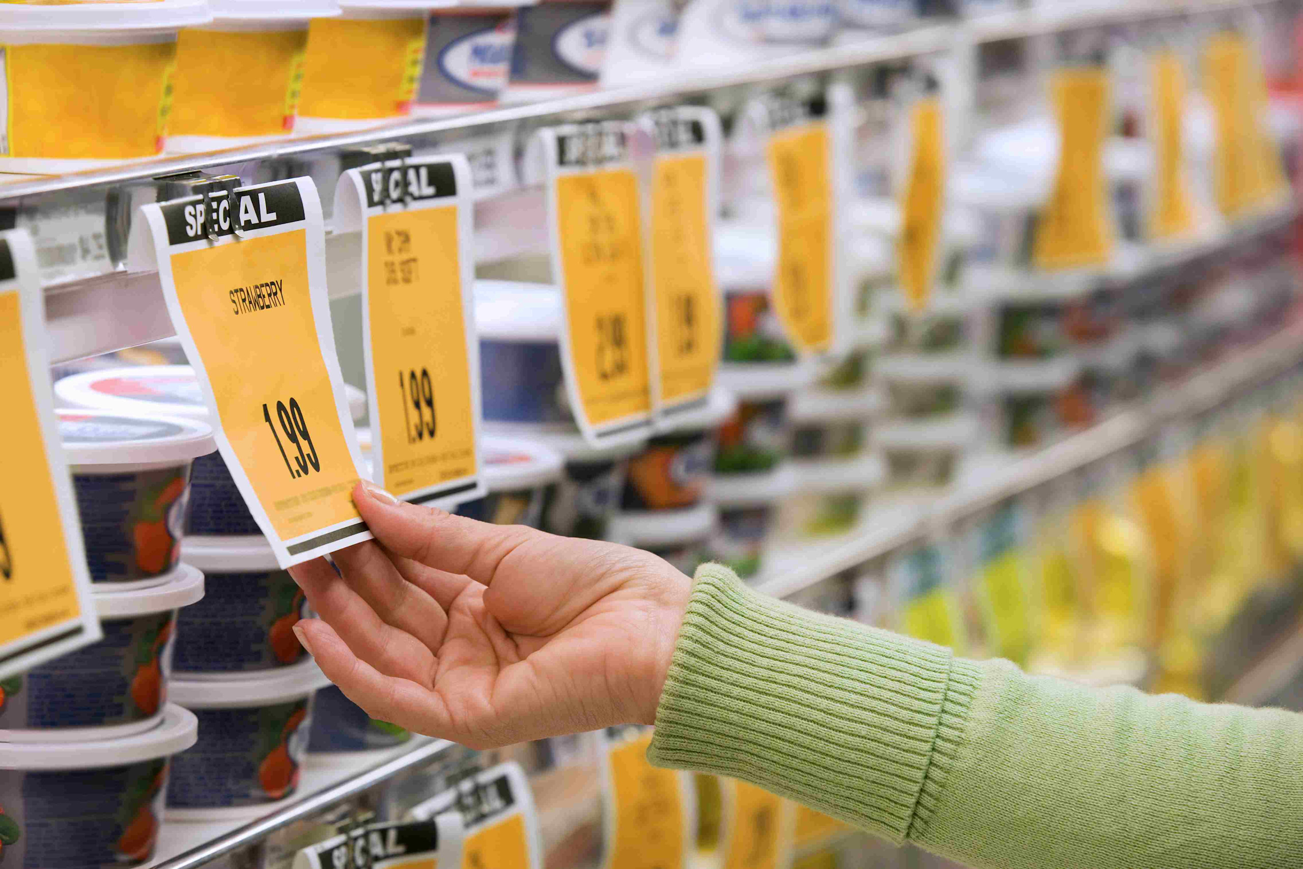 Woman viewing temporary price reductions in cream cheese section section.

