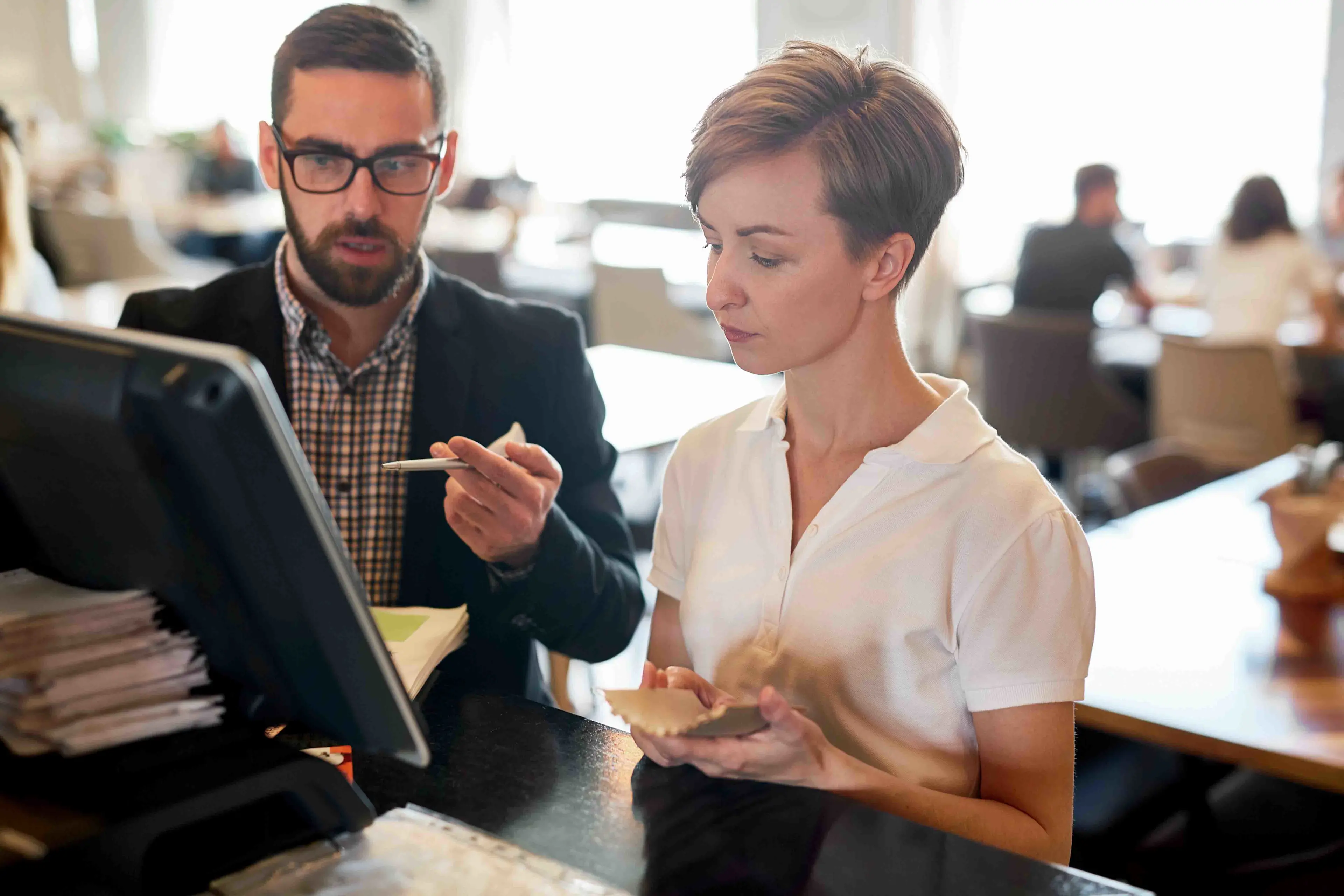 Un(e) vendeur(euse) en train d’examiner des données en compagnie d’un(e) propriétaire de restaurant, en tirant parti d’éléments clés d’aide à la vente