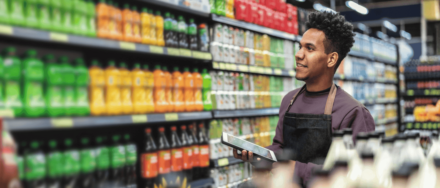 A man using an tablet in a retail store, showcasing the use of retail execution software in action.