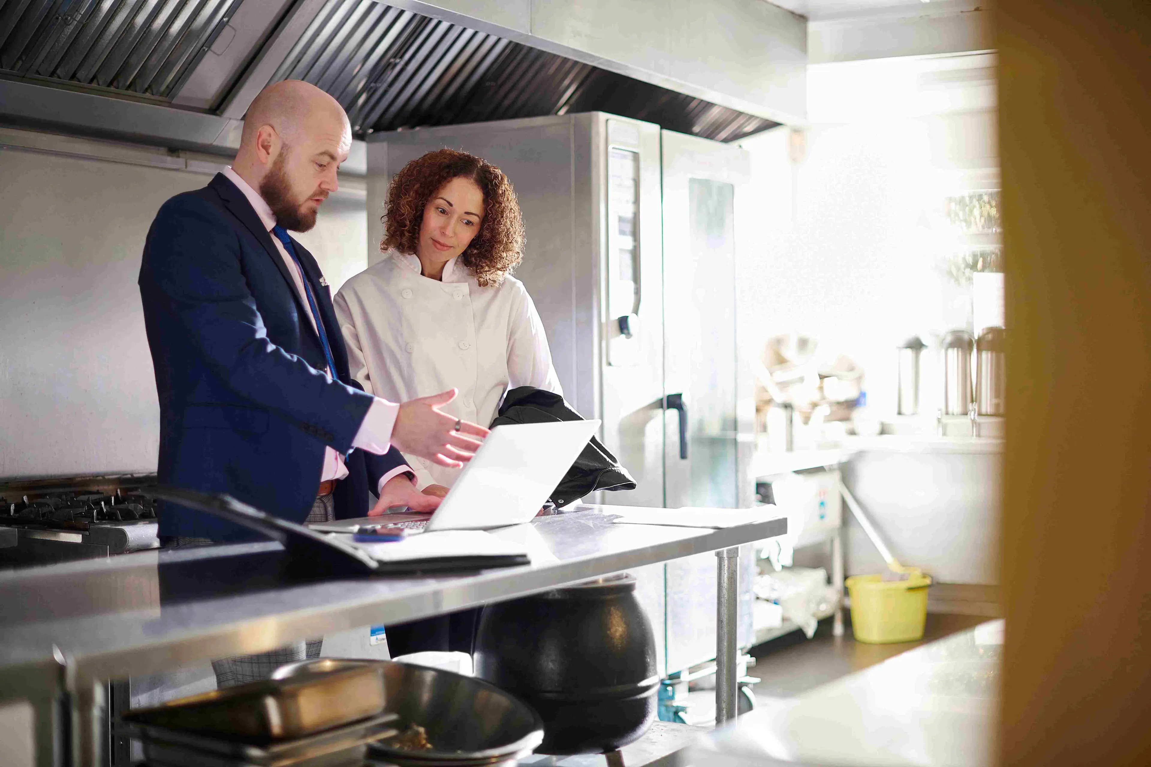 Sales rep views available rebates on laptop in operator’s kitchen


