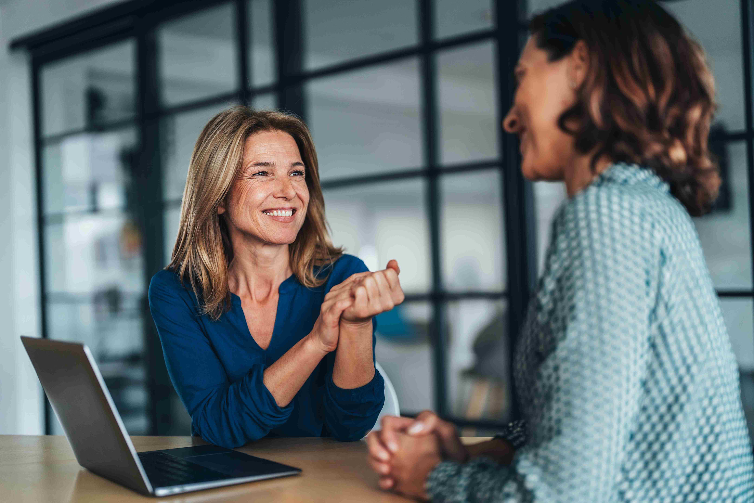 Two women discussing foodservice date in office setting