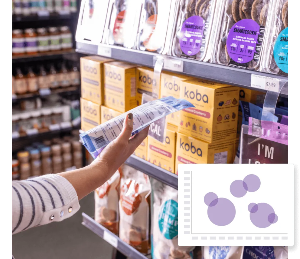 A woman picking up a box of cookies in a store.