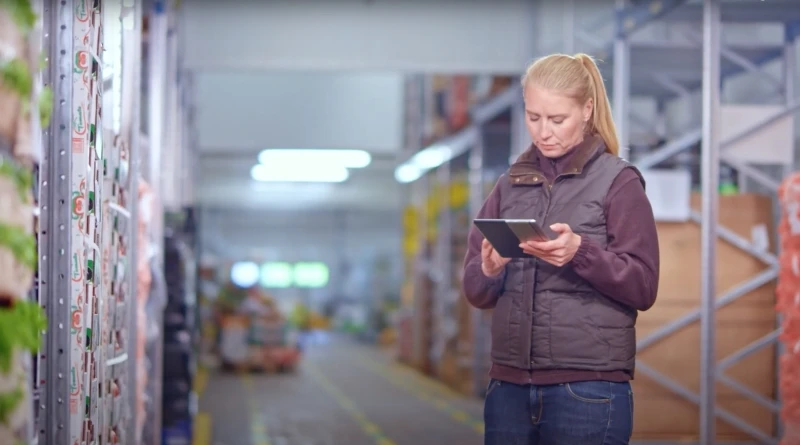 A woman holding a tablet in a warehouse