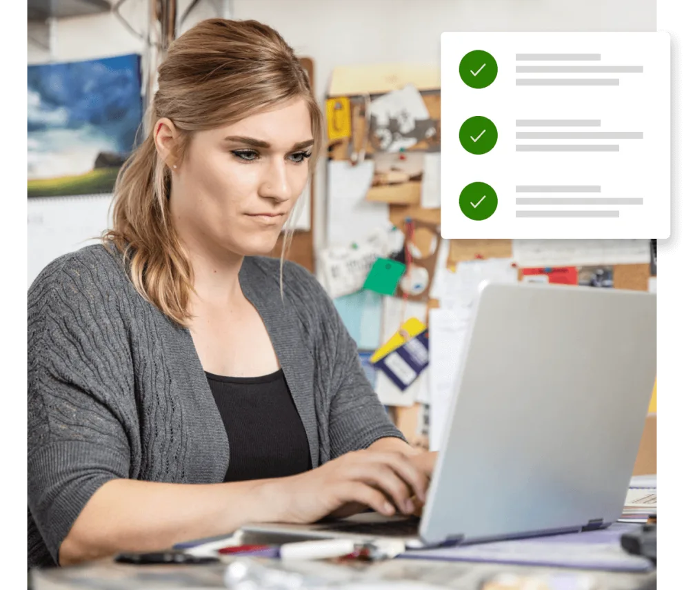 Une femme assise à un bureau et utilisant un ordinateur portable.