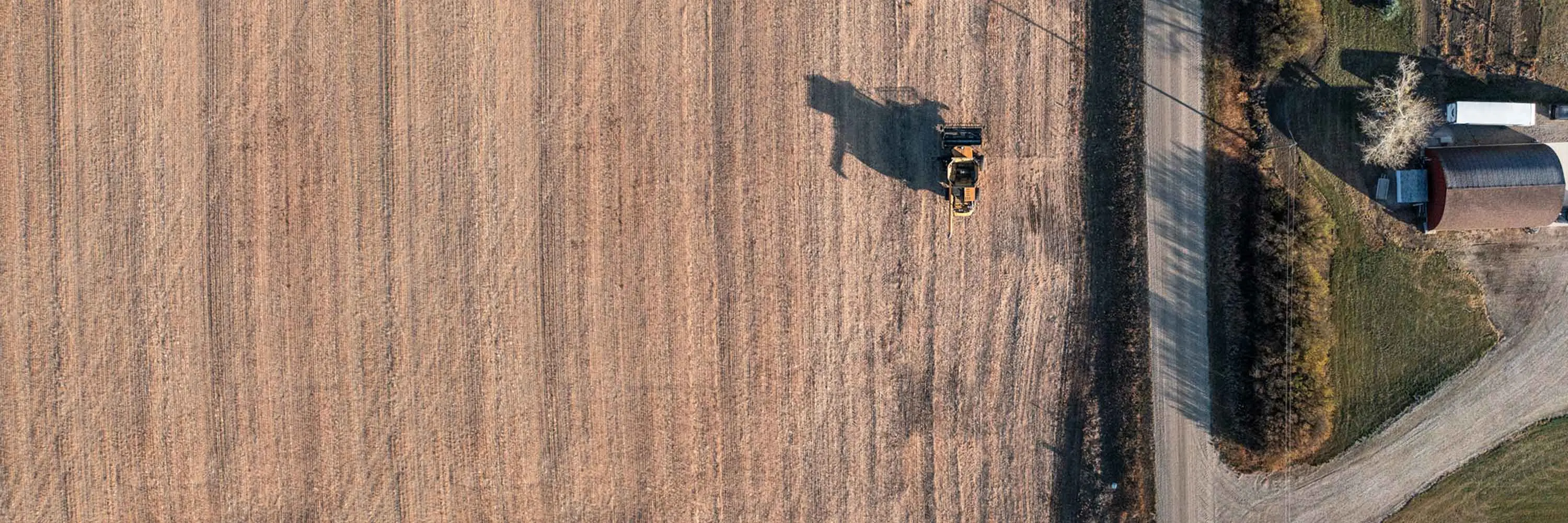 An aerial view of a tractor plowing a field.