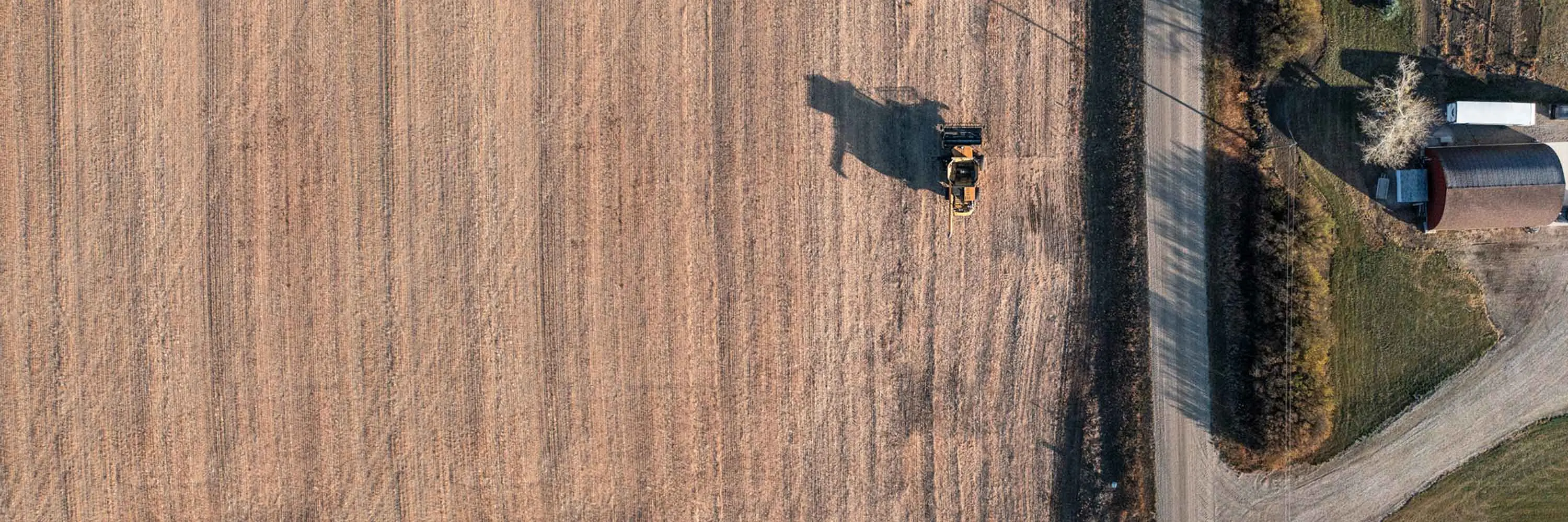 Vue aérienne d'un tracteur labourant un champ.