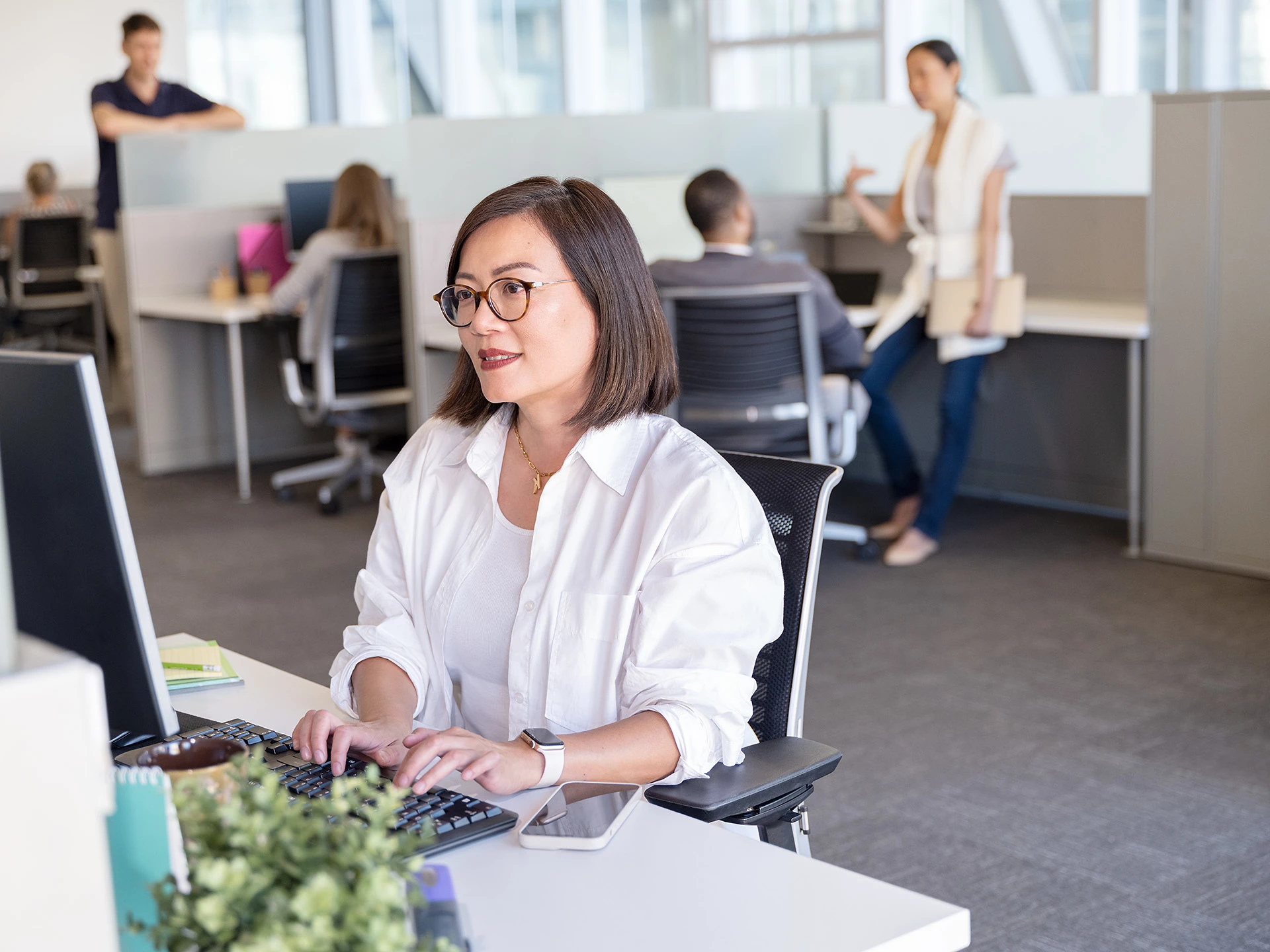 Une femme portant des lunettes est assise à un bureau, axé sur la gestion des remises dans le secteur agricole.