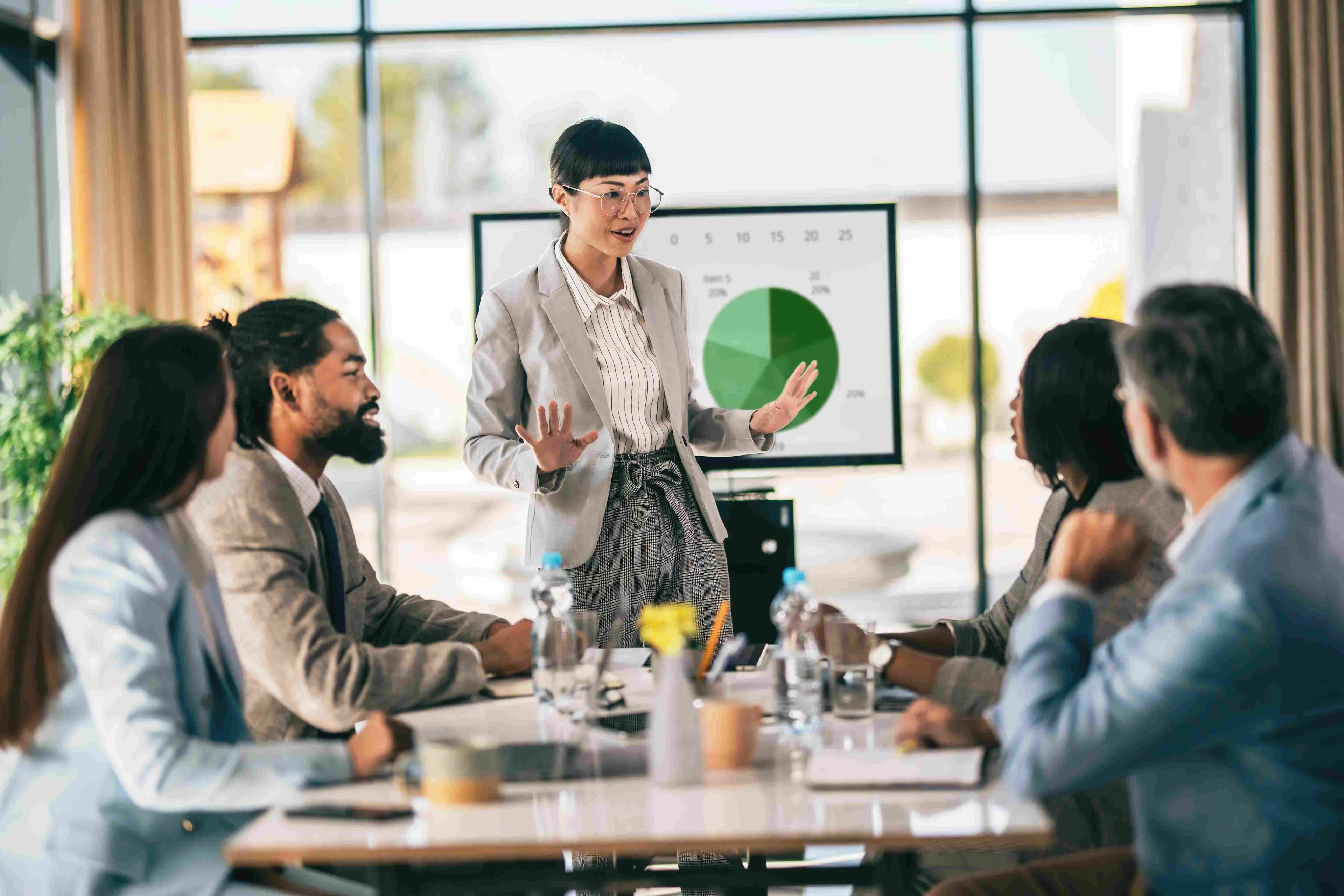 Professional team analyzing trade promotion forecasting data on a tablet in a modern office setting.

