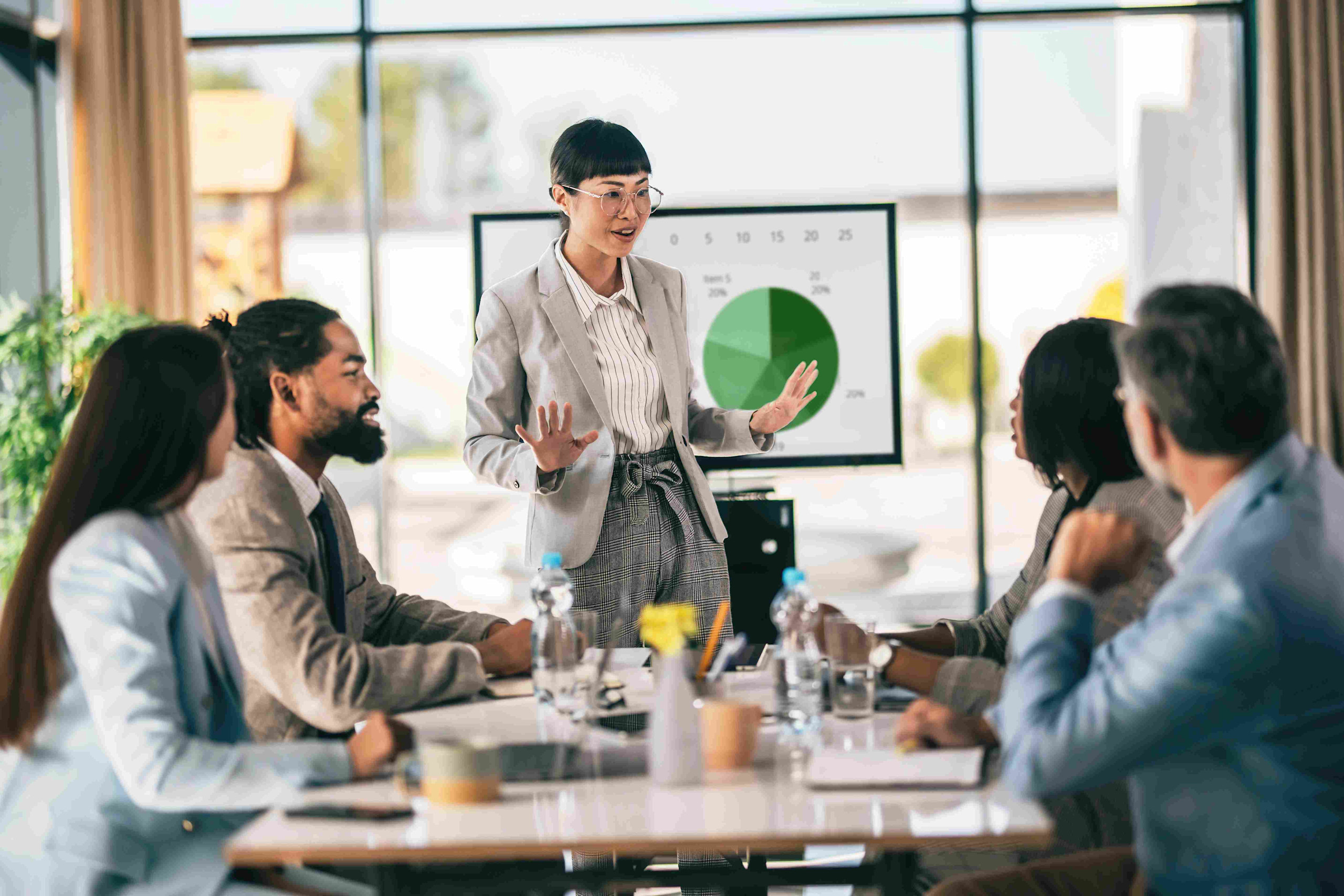 Professional team analyzing trade promotion forecasting data on a tablet in a modern office setting.

