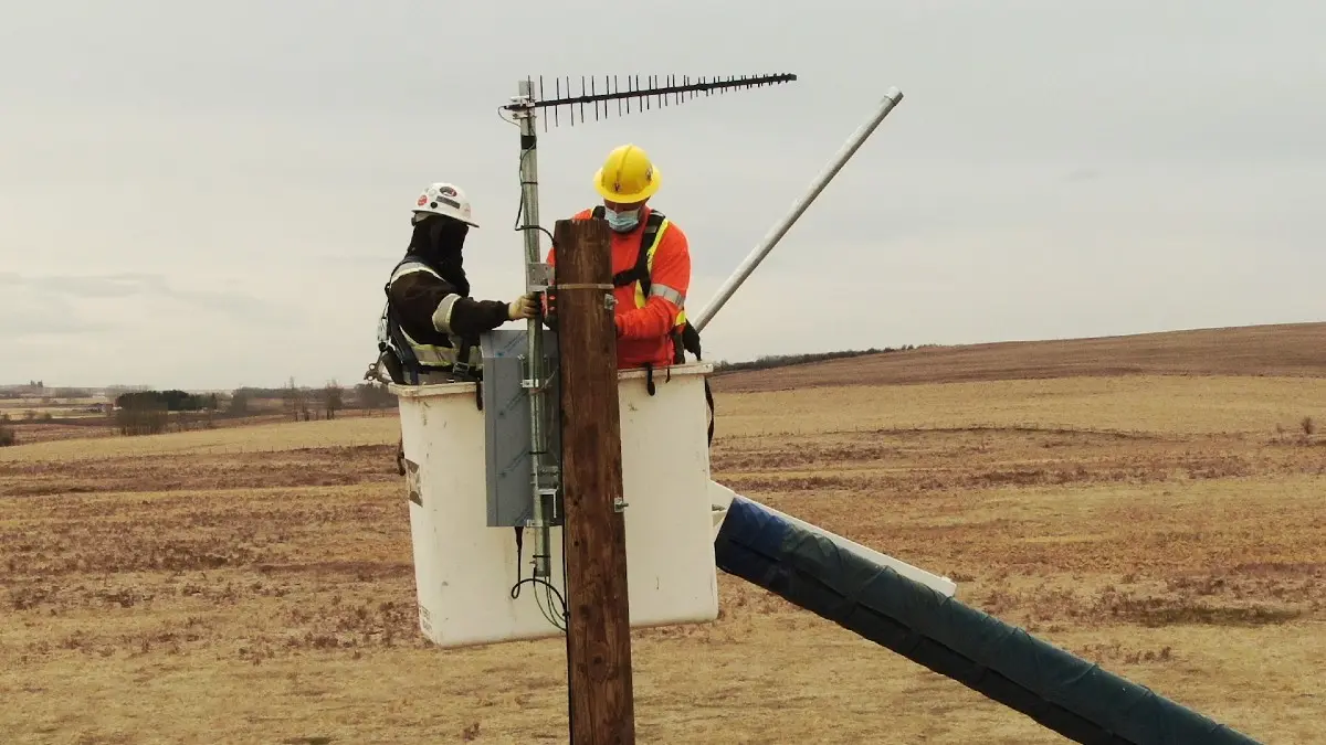 Des techniciens de TELUS installent le répéteur sur la ferme intelligente Olds College.