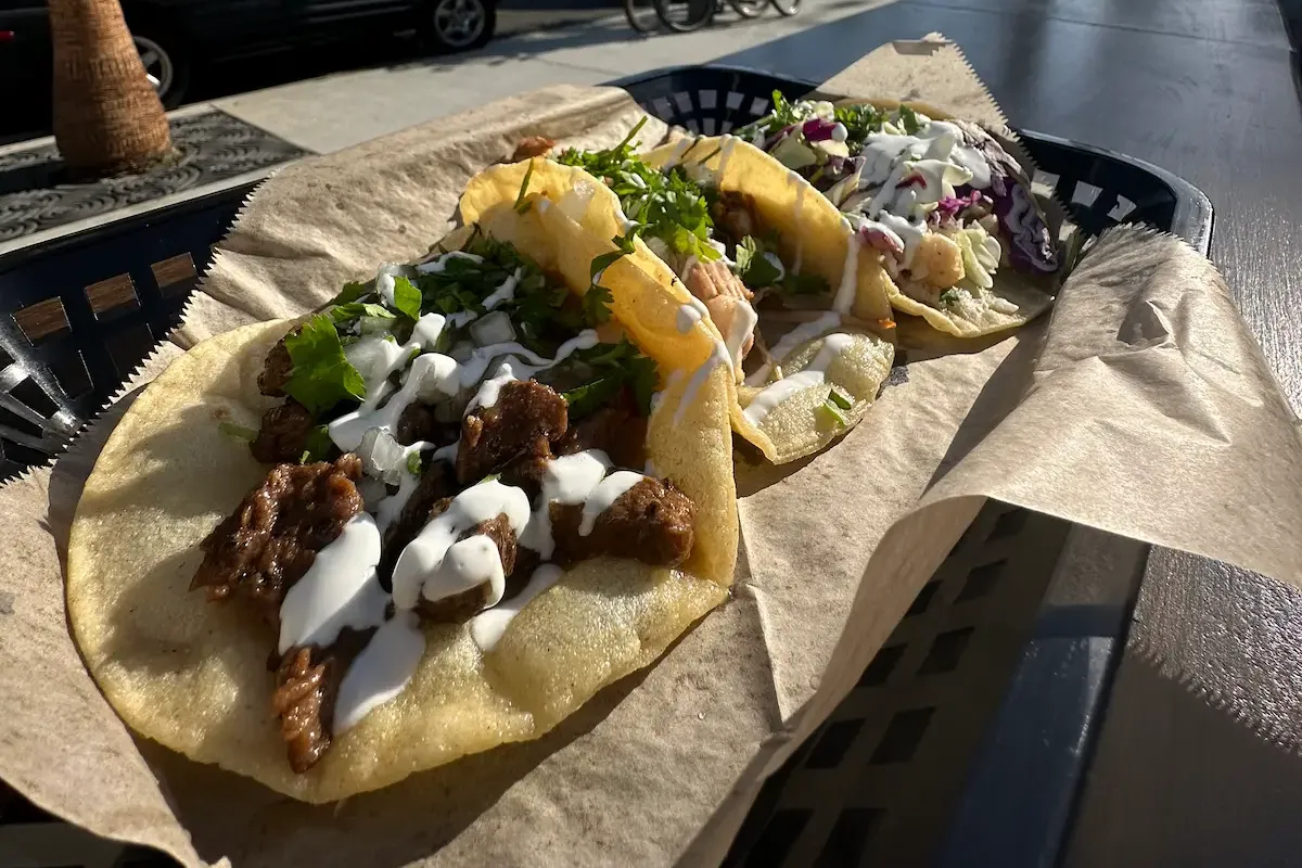 Tacos with meat, sauce, cilantro, and cabbage
