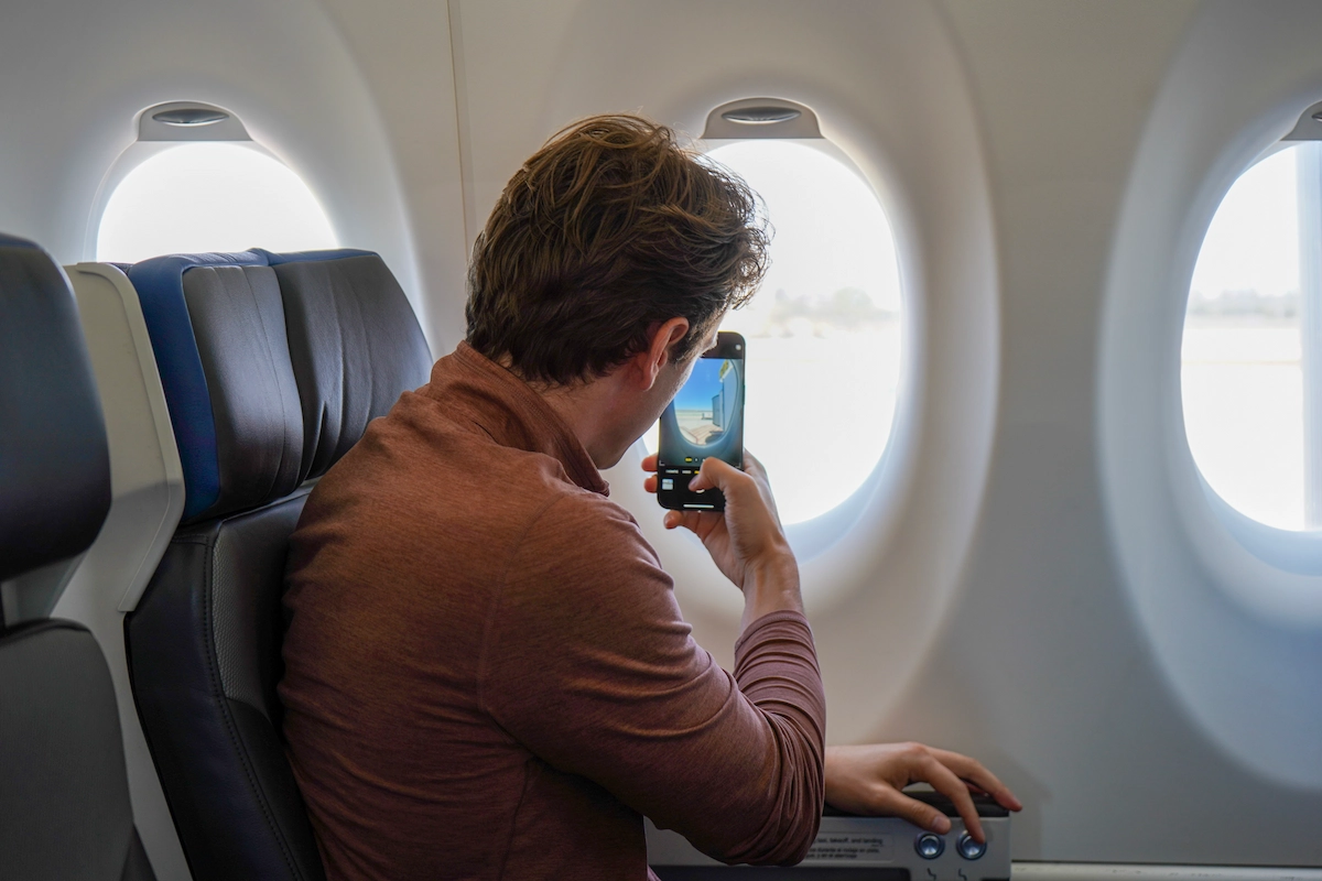 Bru taking a photo out the window of a plane