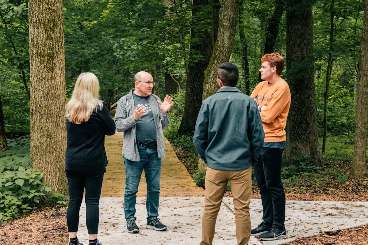 A group of people gathered on a tour of the forest