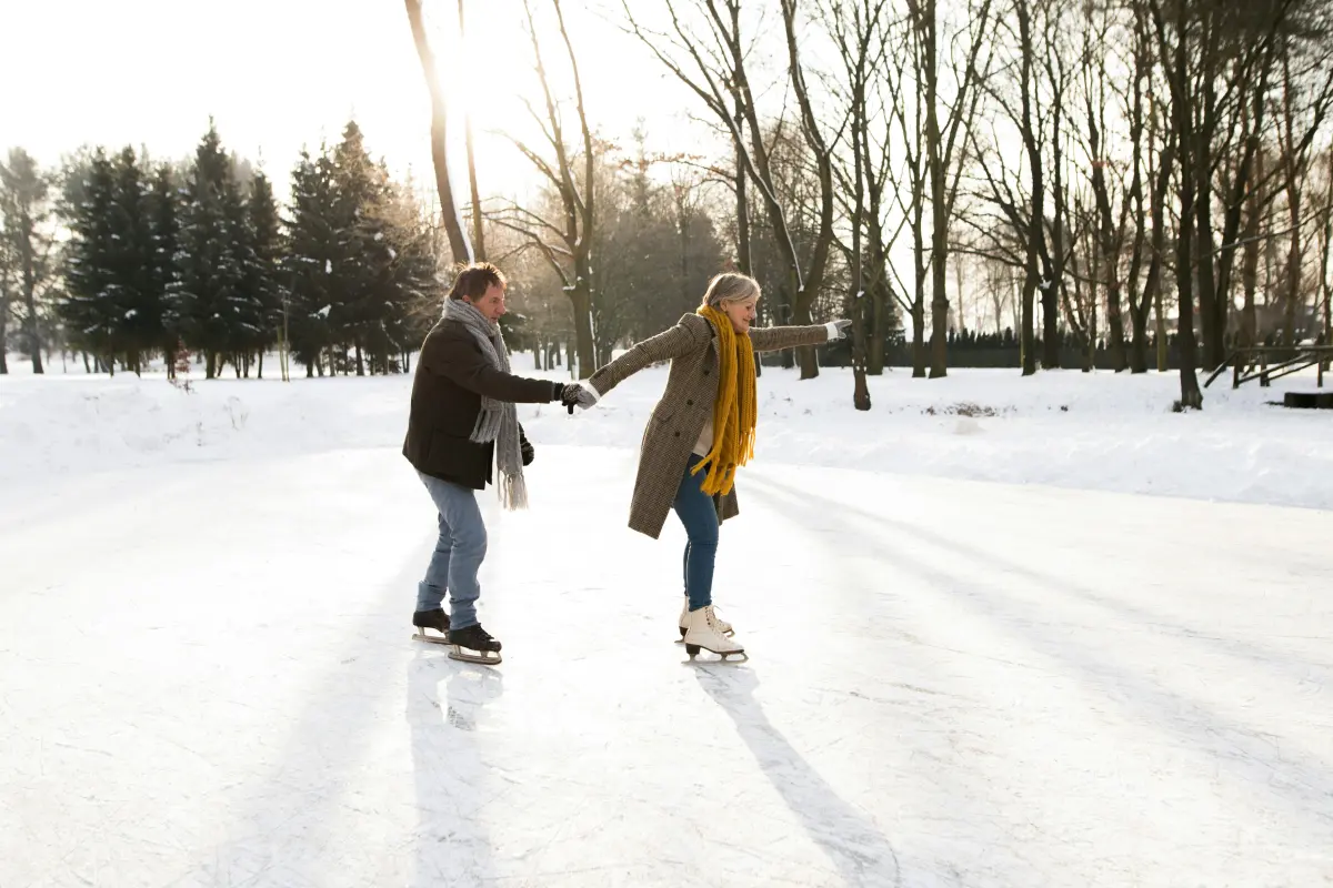 A couple holding hands and ice skating