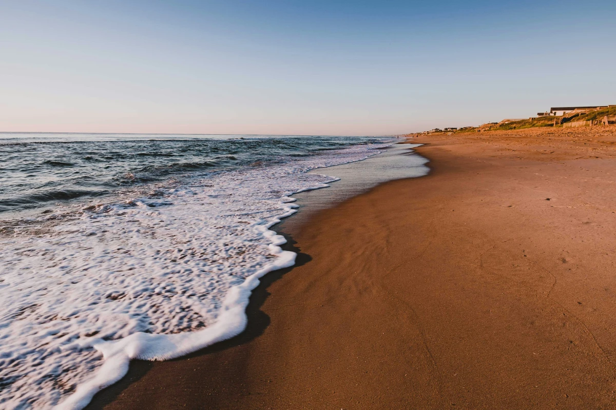 Surf washing up on the beach around sunrise