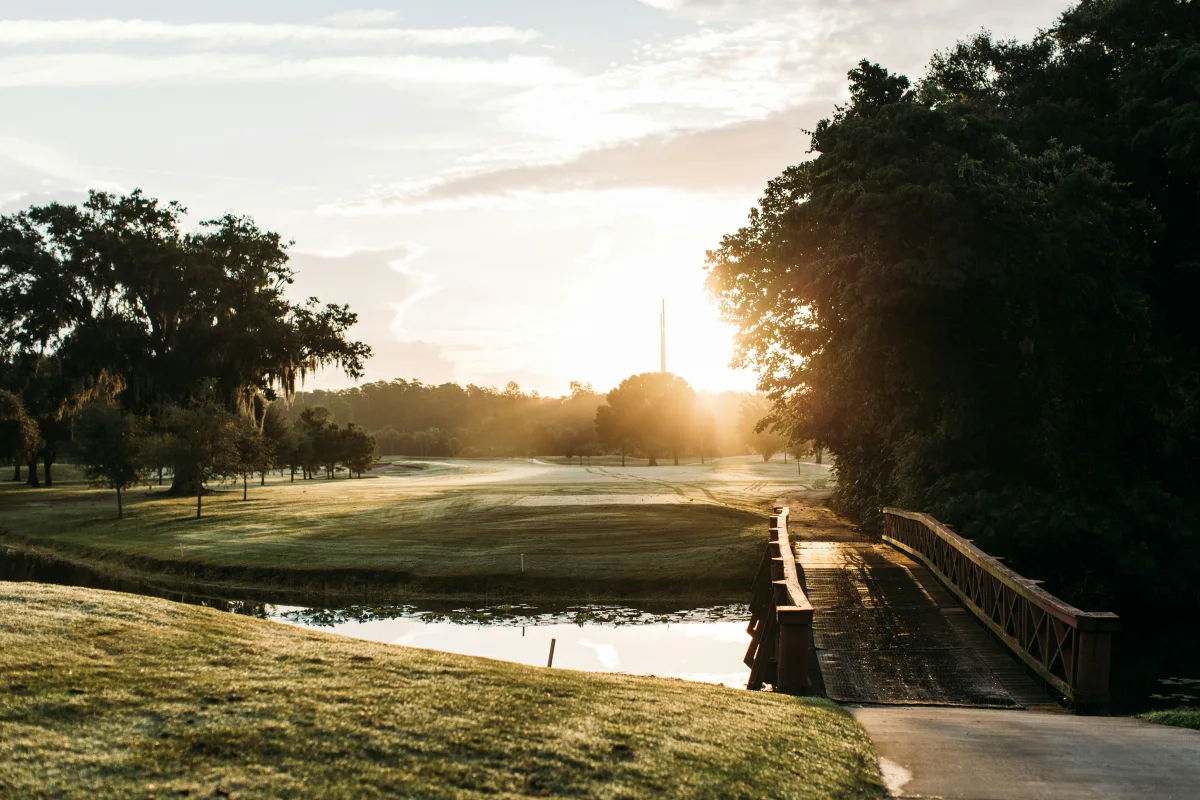 Sunny golf course with a lake and fountains