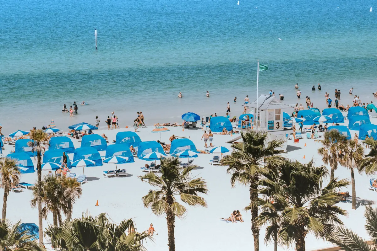 Family walking on wide white sand beach with gentle Gulf waves at Clearwater Beach Florida