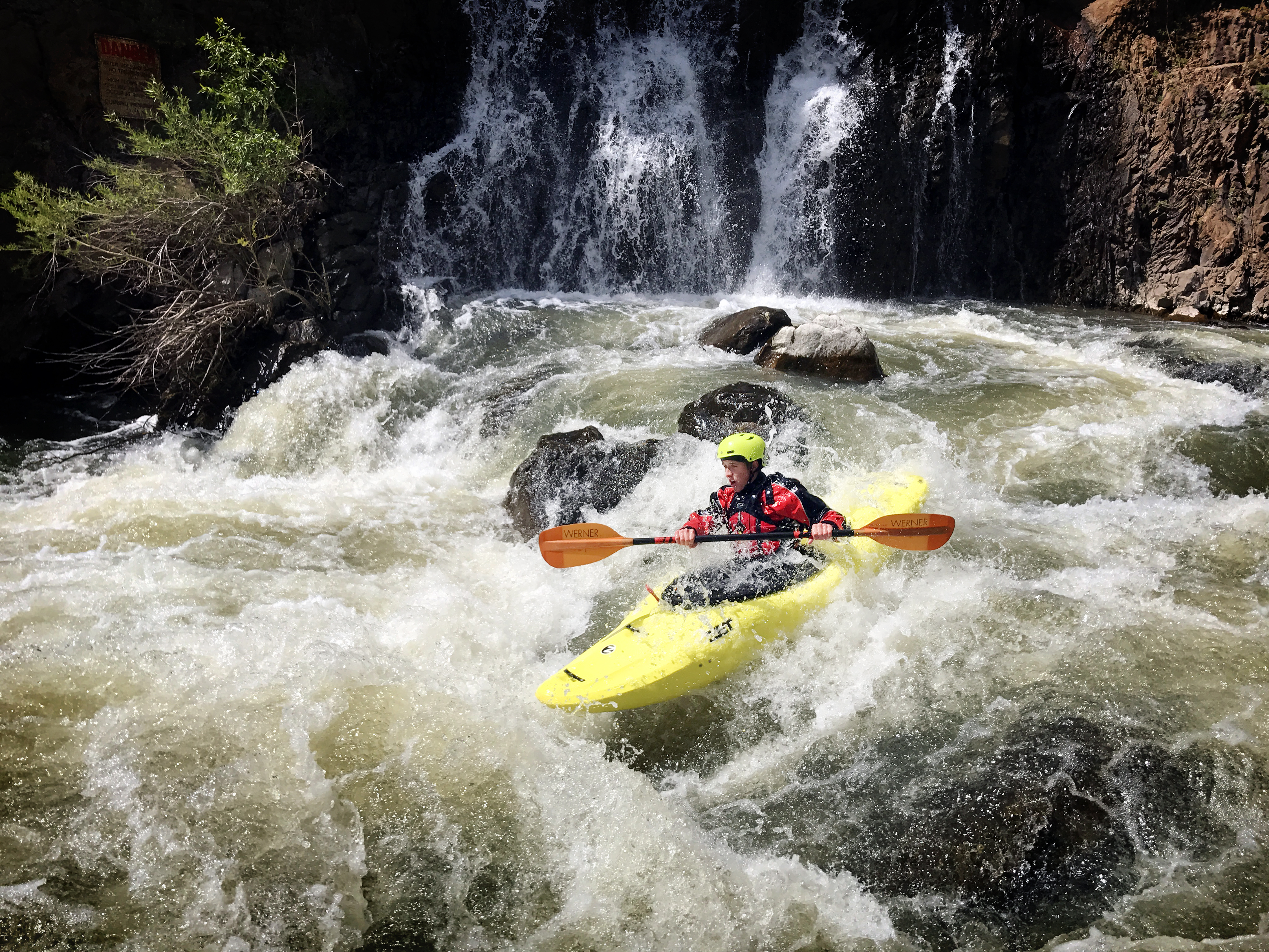 A person kayaking in a rushing river