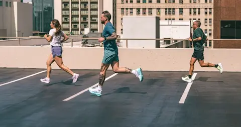 Runners on rooftop parking lot wearing ASICS NovaBlast 6 running shoes