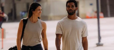 A woman and a man walking outdoors in lightweight running tanks and tees