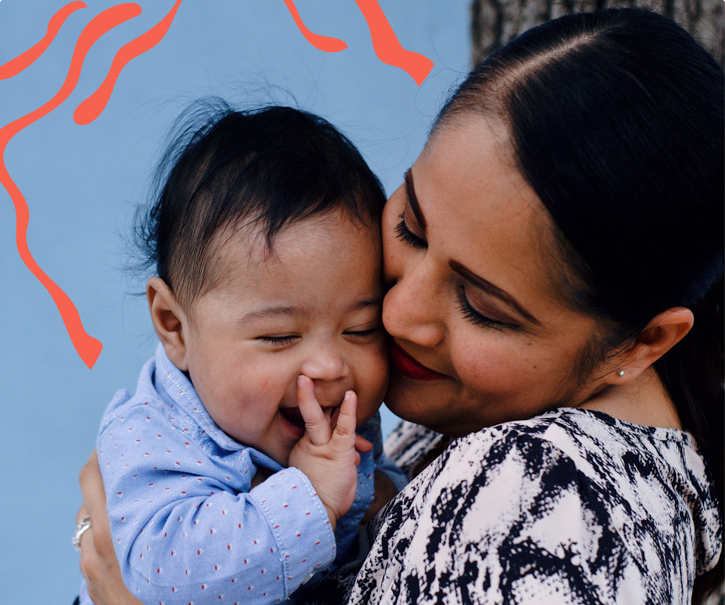 Smiling and happy mom holding her laughing baby