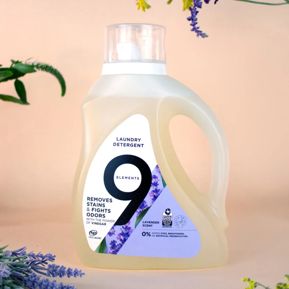 9 Elements lavender laundry detergent bottle with flowers and citruses around.