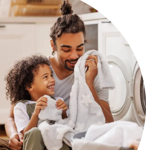 Father holding his child in front of the washing machine.