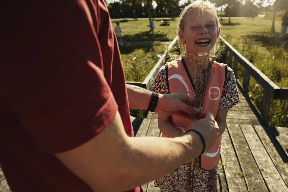 Bso-kind en pedagogisch professional buiten op een brug
