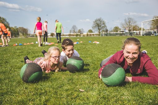 Kinderen en pedagogisch professional op sportveld