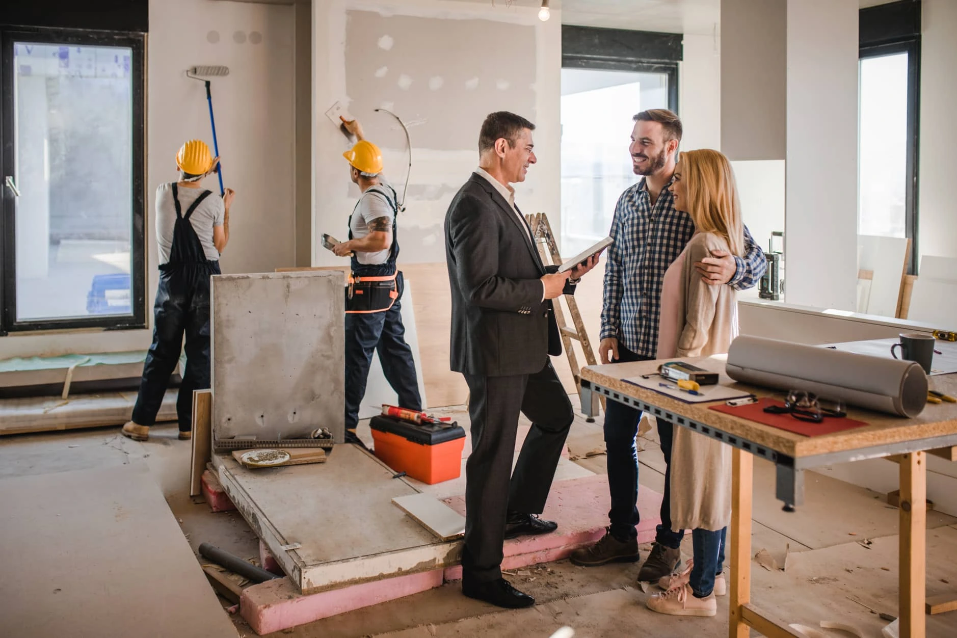 Couple talking with expert, craftsmen in the background