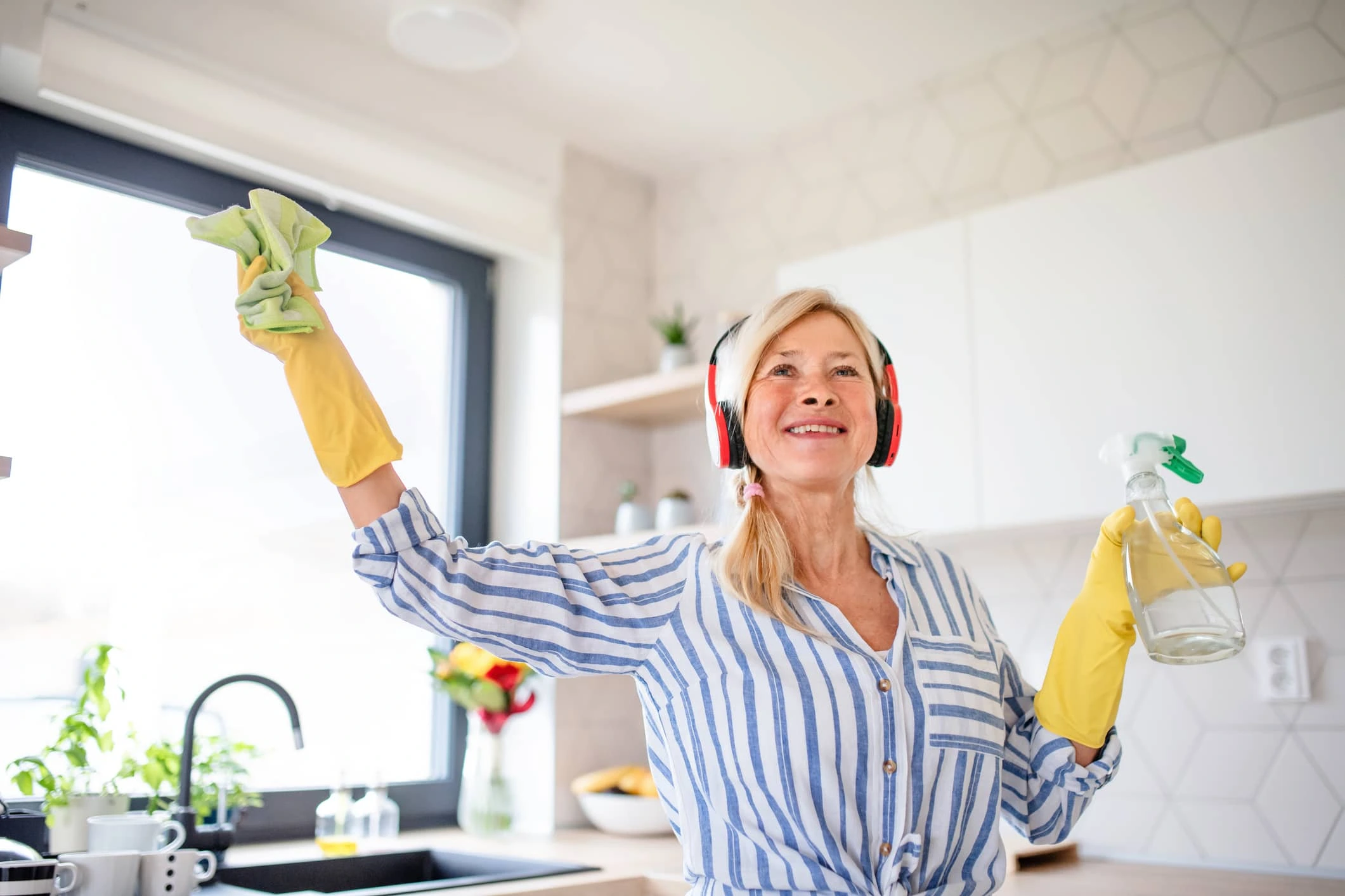 Happy woman does spring cleaning while listening to music