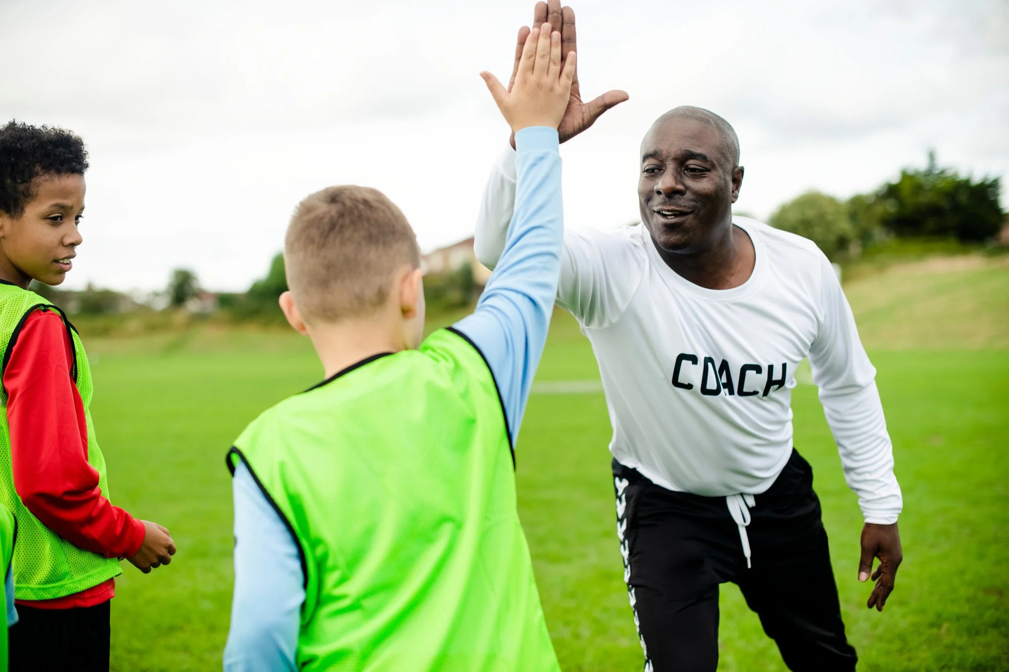 a youth sports coach encouraging his players