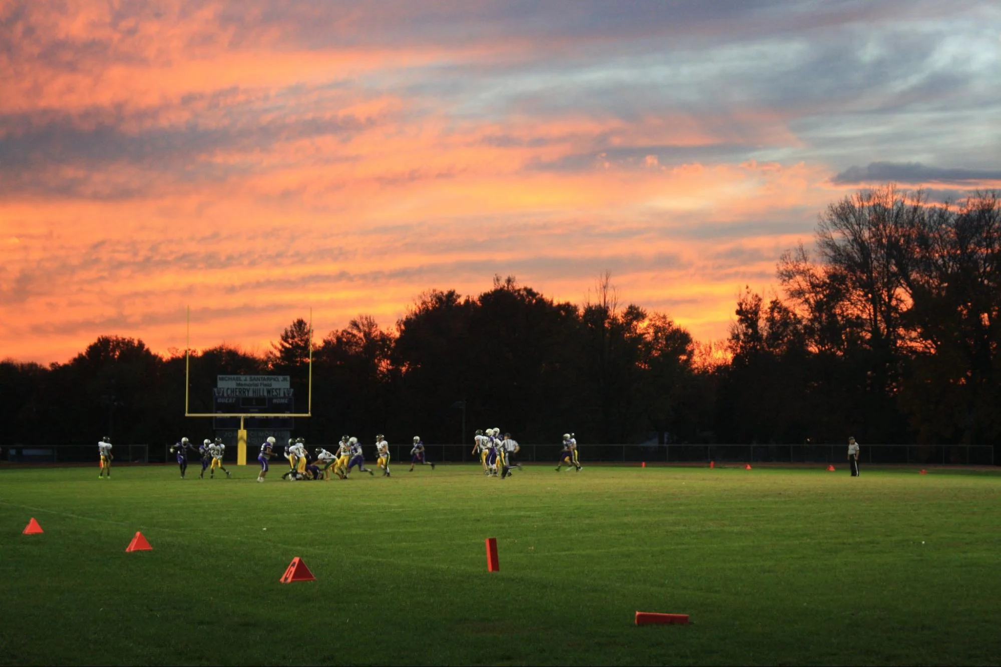 a youth football team practicing in the evening