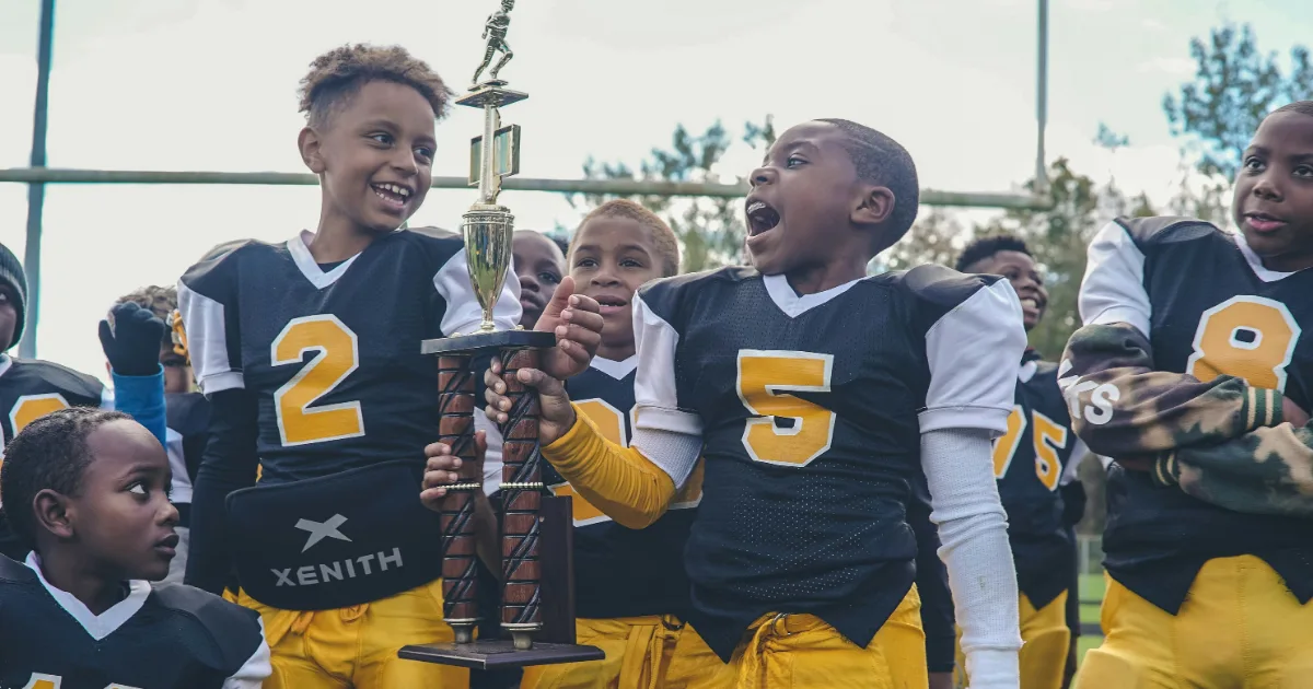 Youth football players holding a trophy after a game