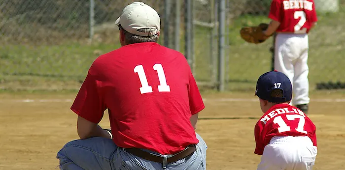 a youth sports coach with a baseball player