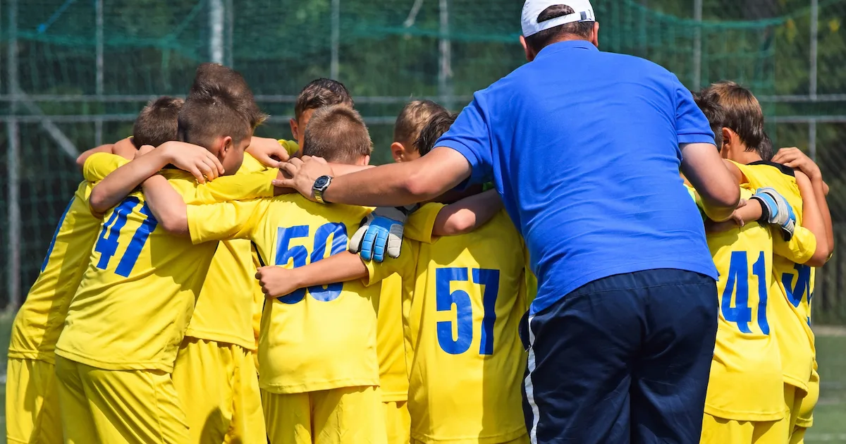 a youth soccer coach preparing with his players for a game