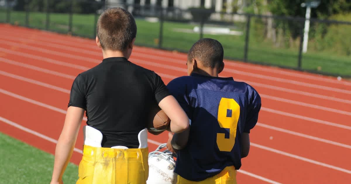 two youth football players talking before their game