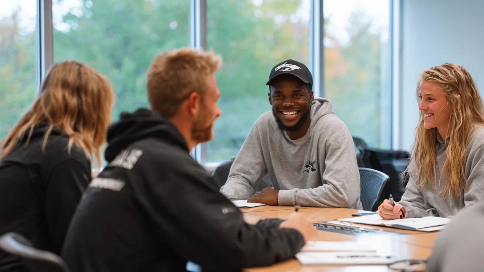Youth sports volunteers sitting at a conference table writing a business plan