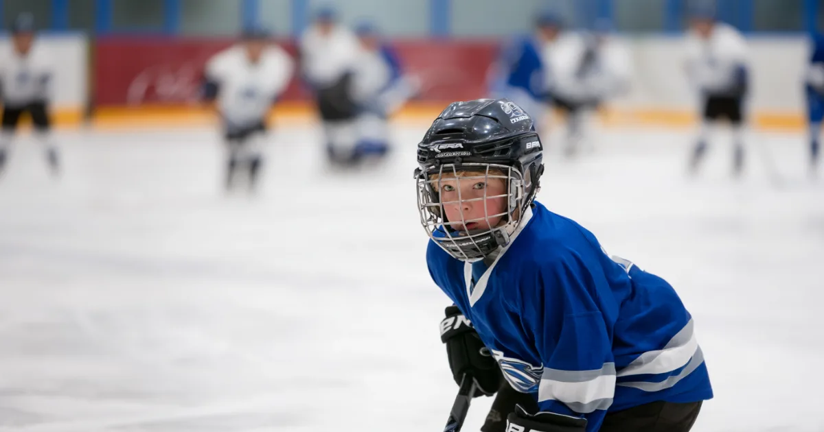 A hockey player on the ice during a game looking at the camera